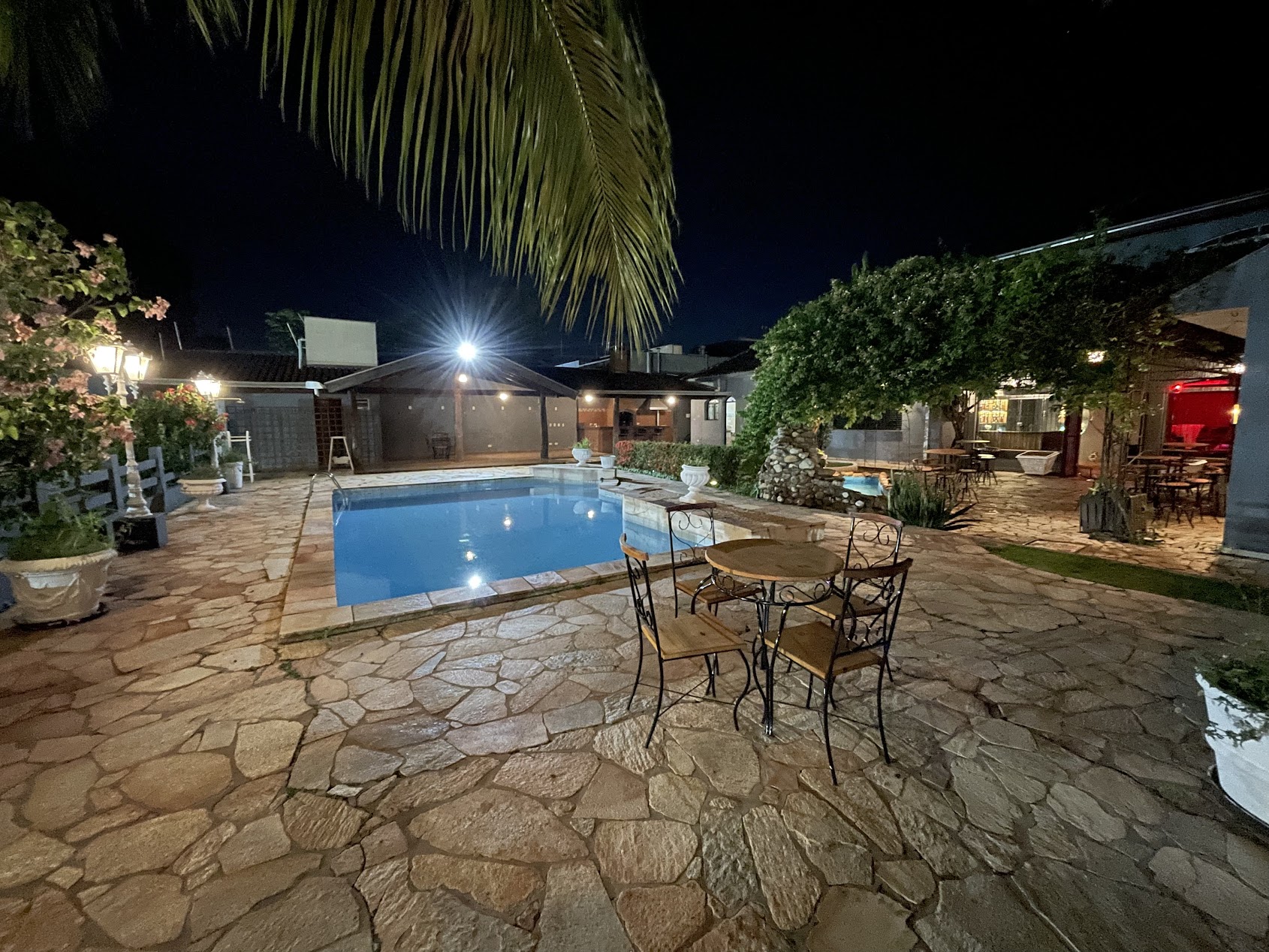 Área externa com piscina e mesas